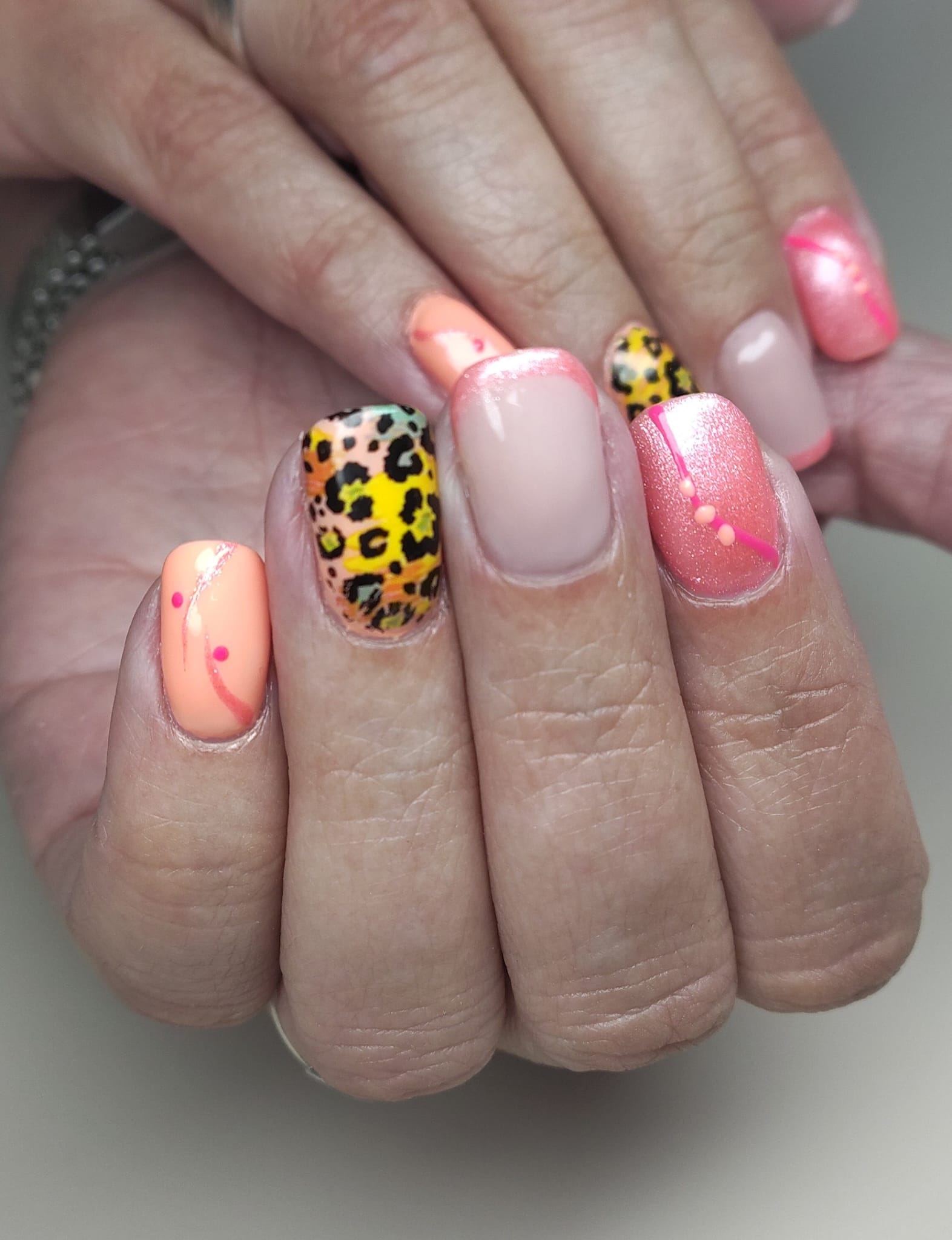 Nail art met luipaardprint op perzik en roze nagels